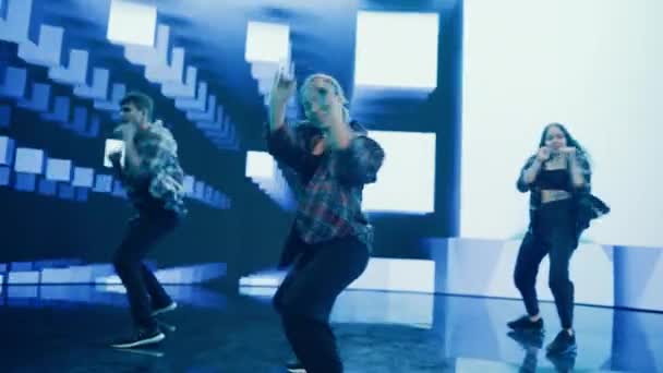 Trzech tancerzy występujących przed animowanym ekranem cyfrowym — Wideo stockowe