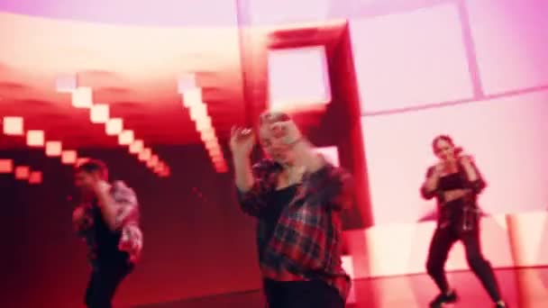 Крупним планом три танцюристи перед анімаційним цифровим екраном — стокове відео