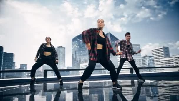 Три танцюристи перед анімаційним цифровим екраном — стокове відео