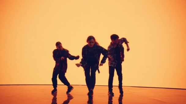 Три танцюристи перед анімаційним цифровим екраном — стокове відео