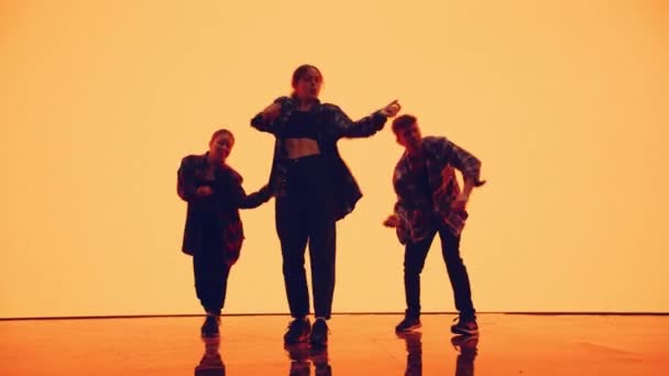 Three Dancers Performing in Front of Animated Digital Screen — Stock Video