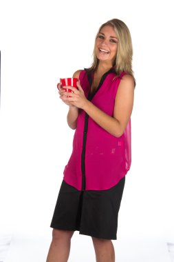 Genç bir kadın elinde bardak tutuyor.