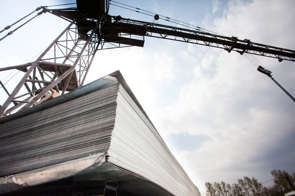 Crane and stack of steel plates — Stock Photo, Image