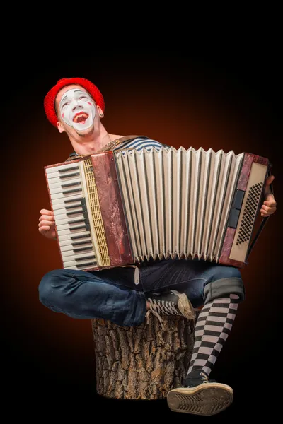 Клоун играет на аккордеоне — стоковое фото