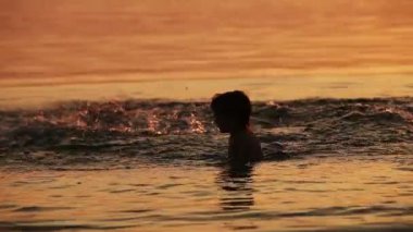 Baba ile oğlu günbatımı dalga dalga dalga geçmeyi