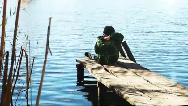 Sam chłopiec rzucać kamieniami w jeziorze wody — Wideo stockowe