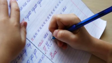 yazılı olarak ilk adımlar: küçük çocuk Rus n harfi çapraz çizgili not defterinde yazıyor