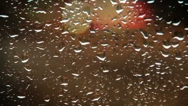 Krople wody deszczowej na szybie samochodu, wieczorem widok ruchu — Wideo stockowe