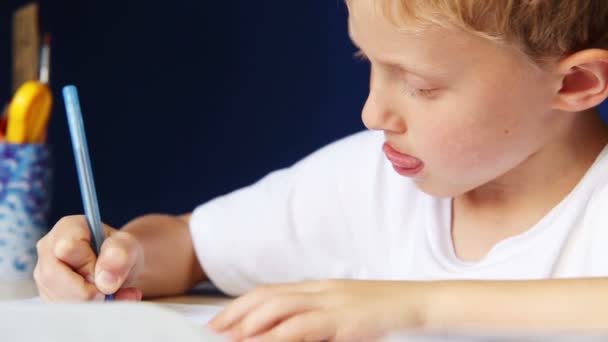 Niño escribe diligentemente su tarea — Vídeos de Stock