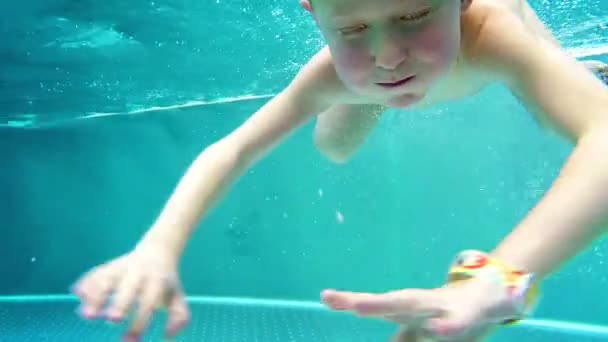 Niño juguetón inmersiones en piscina invierno caliente — Vídeo de stock
