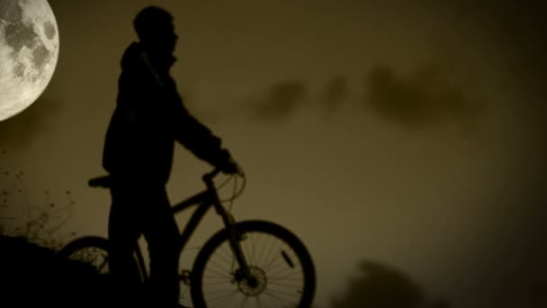 Active biker runs with bicycle in night moonlight — Stok Video