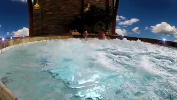 Mladý pár v jacuzzi v nebeské spa resort — Stock video