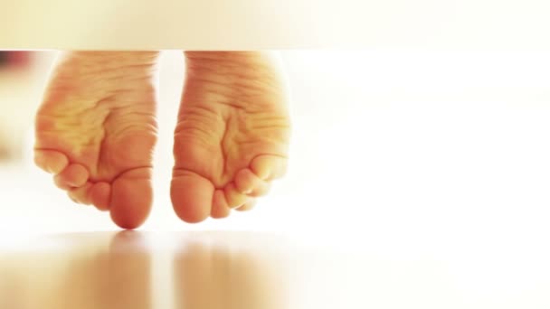 Pari varovasti lapsen jalat laminaattilattia: epätavallinen UNDERbed näkymä — kuvapankkivideo
