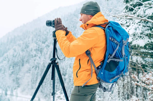 Fotógrafo Chaqueta Naranja Con Mochila Usando Cámara Trípode Paisaje Invernal Fotos de stock libres de derechos