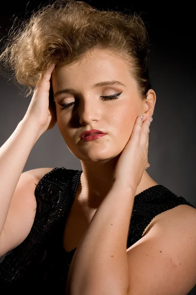 Fille avec les yeux fermés dans une robe noire — Photo