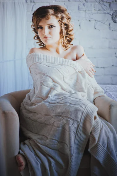 Young woman sitting in armchair — Stock Photo, Image