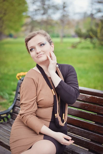 Jeune fille assise sur un banc — Photo