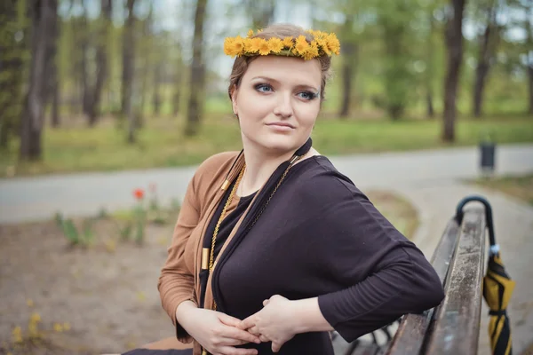 Girl with a wreath of yellow flowers on her head — Stock Photo, Image