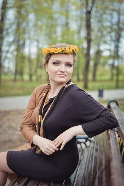 Chica con una corona de flores amarillas en la cabeza — Foto de Stock