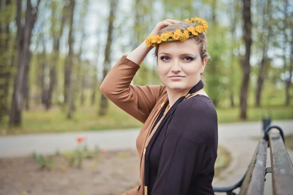 Menina com uma coroa de flores amarelas na cabeça — Fotografia de Stock