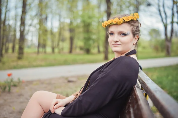 Girl with a wreath of yellow flowers on her head — Stock Photo, Image