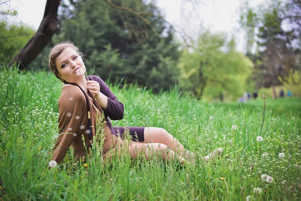Girl blowing on a dandelion — Stock Photo, Image