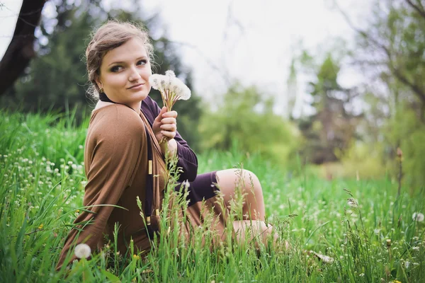 Girl blowing on a dandelion — Stock Photo, Image