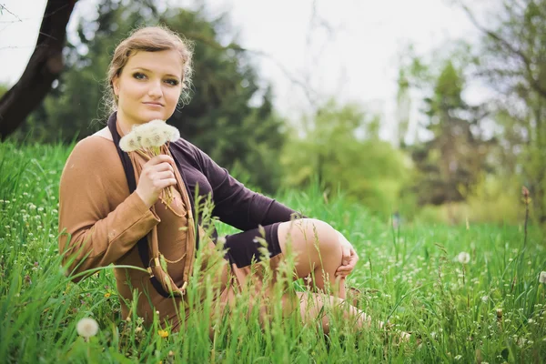 Girl blowing on a dandelion — Stock Photo, Image