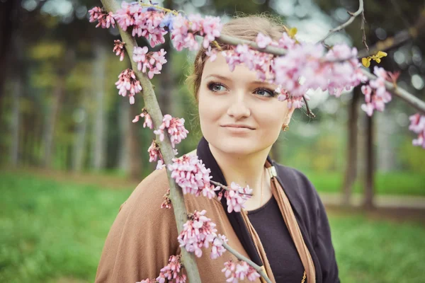 Girl near the spring branches with flowers — Stock Photo, Image