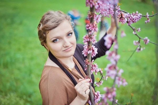 Girl near the spring branches with flowers — Stock Photo, Image