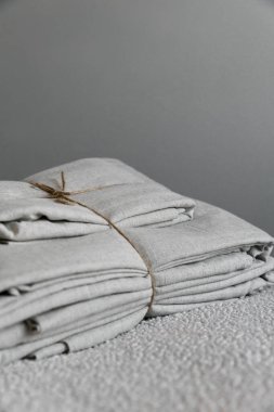 Gri arka planda ve beyaz ovada bej renkli keten kumaş. İple sürüklenmiş.