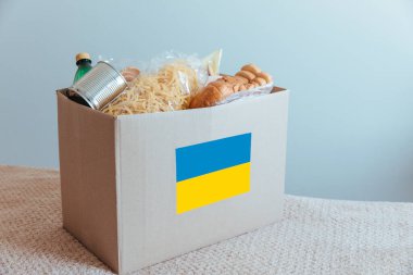 Ukraynalı mültecilere ve muhtaç insanlara insani yardım. Kutuda temel gereksinimler ve yiyecekler yer alıyor: makarna, ekmek, konserve yiyecek, su, kurabiye.