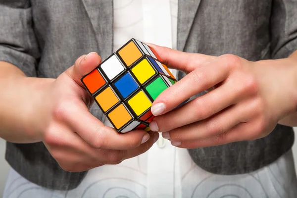 Mãos segurando ou jogando cubo de cor — Fotografia de Stock