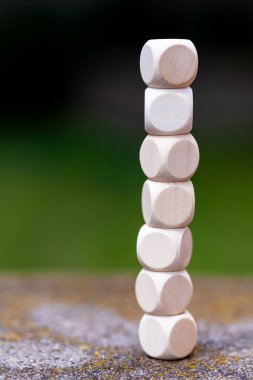 Boş tahta zarlardan oluşan yüksek kule, basit küpler, yığılmış bloklar, basit iş kurumsal dikey arka plan, fotokopi alanı, hiç kimse, açık havada. Düğümler, tasarım elemanları, basitlik ve denge