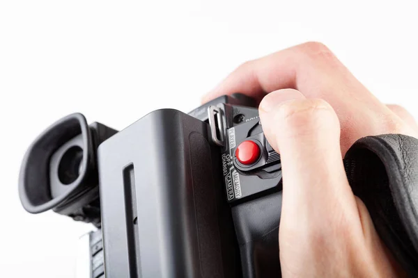 Handheld camcorder, old retro video camera object held in hand, closeup, white background, cut out. Finger on the red rec record button. Filmmaking, movie making abstract concept, first person pov