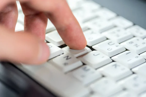 Палец Нажимает Одну Единственную Клавишу Белой Клавиатуре Ноутбука Мелкий Dof — стоковое фото