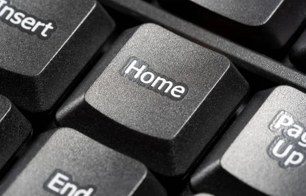 Home button on a simple black desktop PC, computer keyboard, nobody, no people, object macro, detail, extreme closeup. Home text symbol, real estate development, house mortgage, loan abstract concept