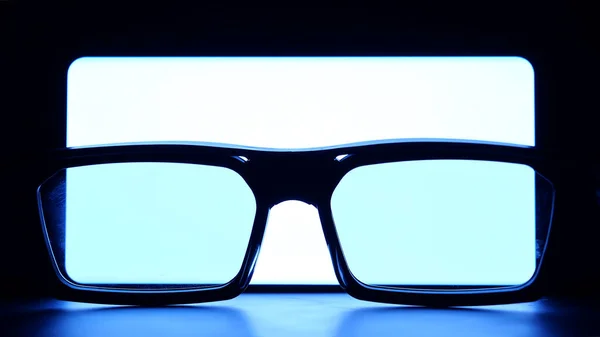 Okulary Umieszczone Przed Jasnym Białym Ekranem Smartfona Urządzenie Mobilne Wyświetlacz — Zdjęcie stockowe