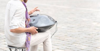 Trampet çalan adam, pervane, çelik kaplama açık havada, eller yakın çekim, yavaş çekim. Müzik, alışılmadık perküsyon enstrümanları, rahatlama konsepti, bir kişi