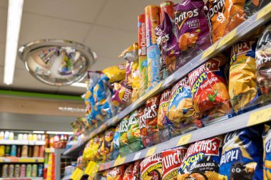 Lots of chips and crisps in a Zabka convenience store, product display, group of objects closeup, nobody, no people, store interior, shop hall inside, detail