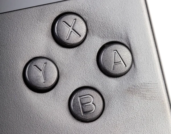 YXAB buttons on a simple retro video game controller, object macro, extreme closeup, nobody. Retro game systems emulation, emulators, console games and gaming