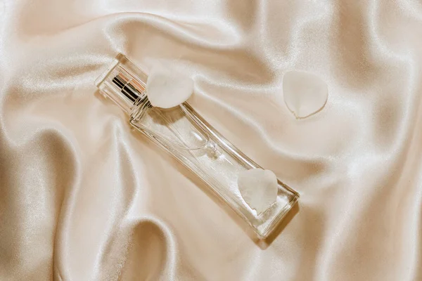 Parfum Fles Witte Bloemblaadjes Een Zijden Beige Achtergrond Ruimte Voor — Stockfoto