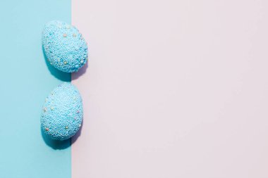 Pastel pembe ve mor arka planda mavi paskalya dekoratif yumurtaları..