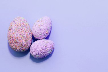 Pastel arka planda mor Paskalya dekoratif yumurtaları..
