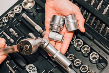 Bir sürücü için arka planda alet anahtarı ve fındık tutan eller..