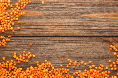 Ahşap zemine saçılmış kırmızı mercimek..