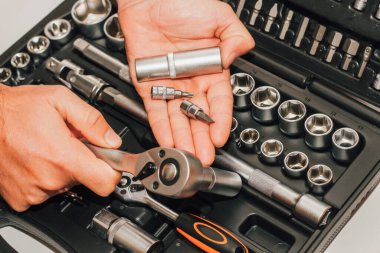 Bir sürücü için arka planda alet anahtarı ve fındık tutan eller..