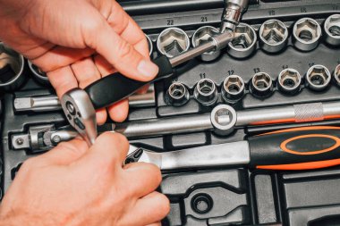 Bir sürücü için arka planda alet anahtarı ve fındık tutan eller..