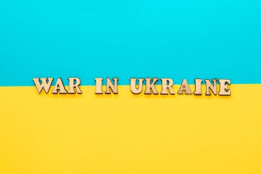 Ukrayna 'daki tahta yazıt savaşı mukavva bir arka planda Ukrayna mavi-sarı bayrağı.