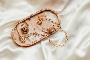 Alçıtaşı mermer süsleme standı ve ipek standın arka planında altın süsleme.